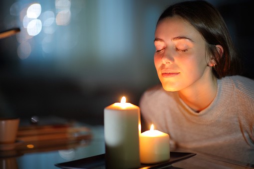 a girl enjoying scented candles 